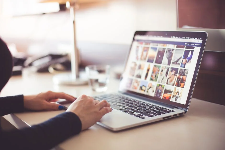 A person using a laptop to browse stock photo websites. Freelancing work in a cozy setting.