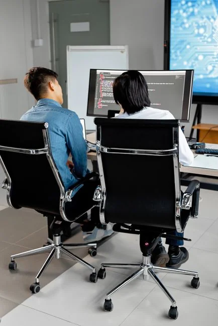 High-angle view of a stylish work desk featuring dual monitors, keyboard, mouse, and modern accessories.