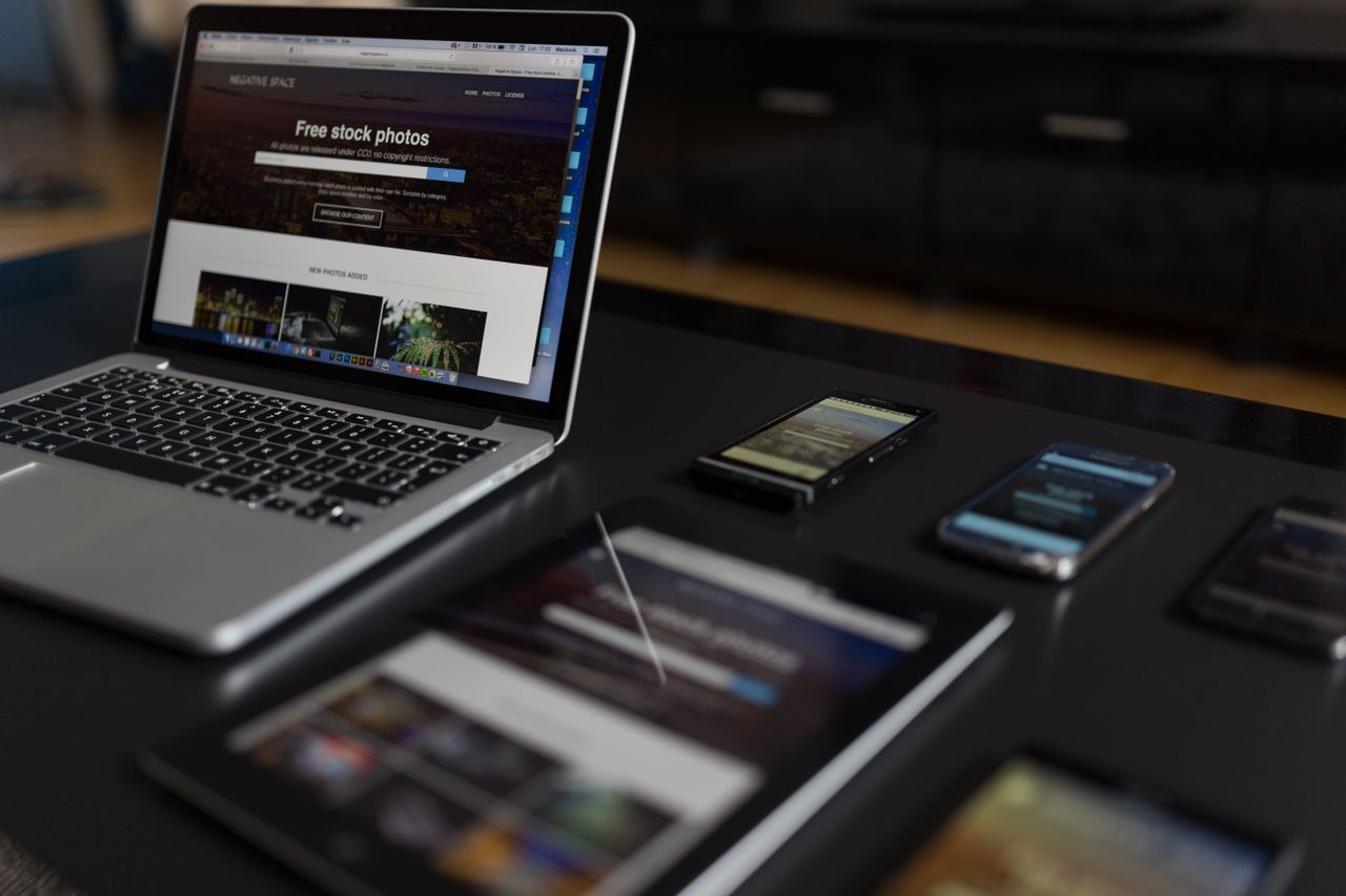 Un espace de travail moderne avec un ordinateur portable, une tablette et des smartphones, parfait pour les professionnels tech et les indépendants.